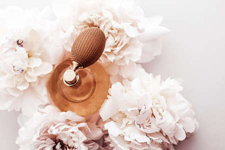 Fragrance bottle as vintage perfume product on background of peony flowers, parfum ad and beauty...