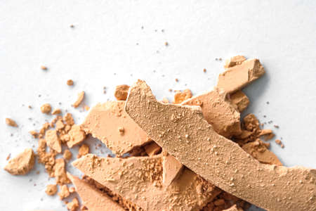 Beige eye shadow powder as makeup palette closeup isolated on white background, crushed cosmetics...