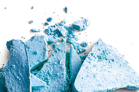 Blue eye shadow powder as makeup palette closeup isolated on white background, crushed cosmetics and...