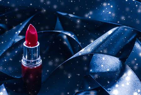 Red lipstick on blue silk and shiny glitter background, luxury make-up and beauty cosmeticsの写真素材