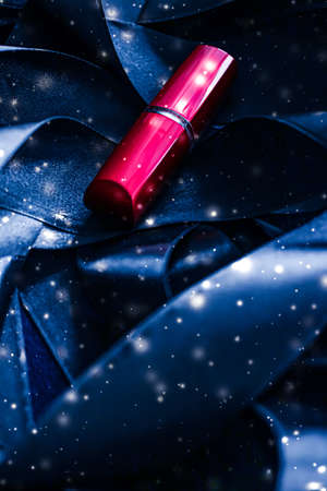 Red lipstick on blue silk and shiny glitter background, luxury make-up and beauty cosmeticsの写真素材