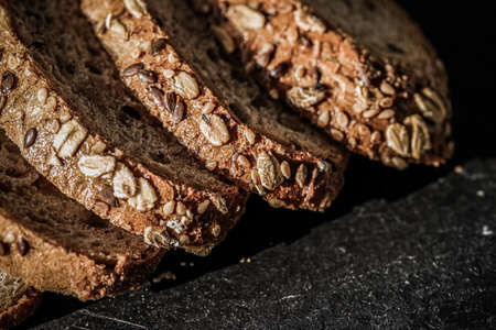 Fresh whole grain seeded bread, organic wheat flour, closeup slice texture as background for food...