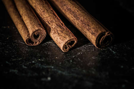 Cinnamon sticks on black stone background, food recipesの写真素材