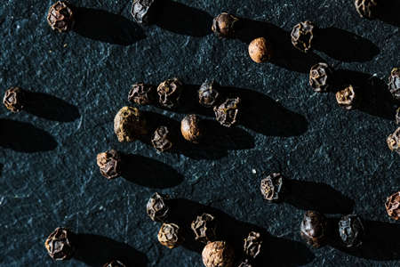 Black pepper closeup on luxury stone background as flat lay, dry food spices and recipe ingredientsの写真素材