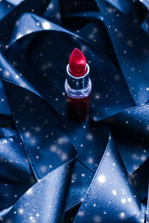 Red lipstick on blue silk and shiny glitter background, luxury make-up and beauty cosmeticsの写真素材