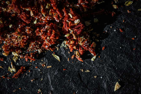 Dried tomato and chili pepper closeup on luxury stone background as flat lay, dry food spices and recipe ingredientsの写真素材