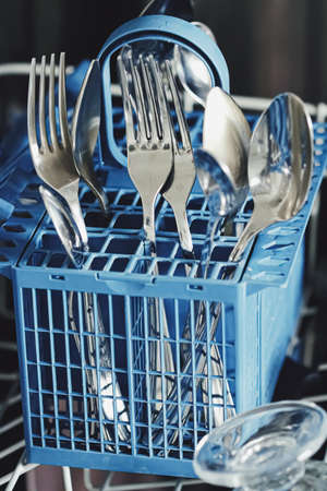 Open dishwasher machine with clean dinnerware in the kitchen, closeupの写真素材