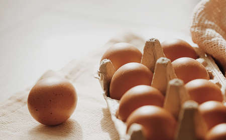 organic farm eggs in egg box and rustic cloth napkins, closeupの写真素材