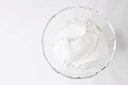 White whipped dessert cream served in a glass bowl, creamy texture closeupの写真素材