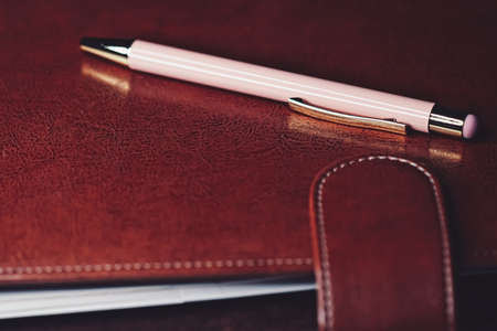Pen and leather briefcase in office, closeupの写真素材