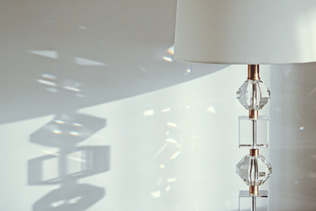 Gold and crystal details of a bedside lamp with shadows at sunset, luxury home decor closeupの写真素材