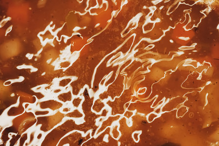 Vegetable soup with beans boiling in a saucepan, homemade food closeup