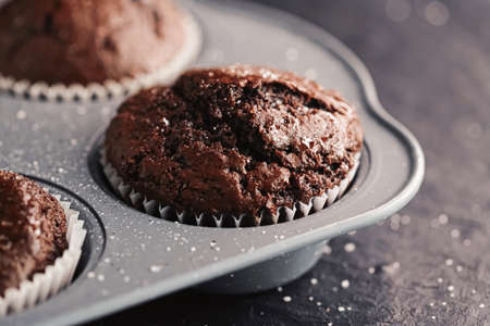 Just baked chocolate muffins in tray, homemade comfort food recipe conceptの写真素材