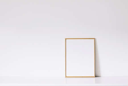 Golden vertical frame on white furniture, luxury home decor and design for mockup creationの写真素材