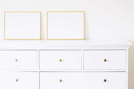 Two golden horizontal frames on white furniture, luxury home decor and design for mockup creationの写真素材