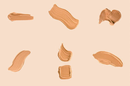 Liquid foundation smudges, smears and strokes as makeup textures isolated on beige background, beauty and cosmeticsの写真素材