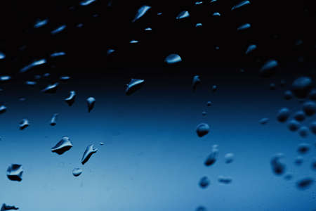 Liquid water drops on glass surface, abstract backdrop and science background