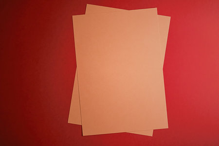 Beige A4 papers on red background as office stationery flatlay, luxury branding flat lay and brand identity design for mockupの写真素材