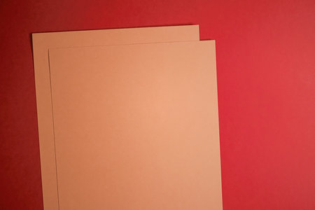 Beige A4 papers on red background as office stationery flatlay, luxury branding flat lay and brand identity design for mockupの写真素材