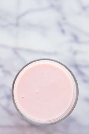 Strawberry milk on marble background as sweet drink, food service and meal deliveryの写真素材