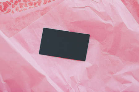 Black business card flatlay on pink tissue paper background, luxury branding flat lay and brand...