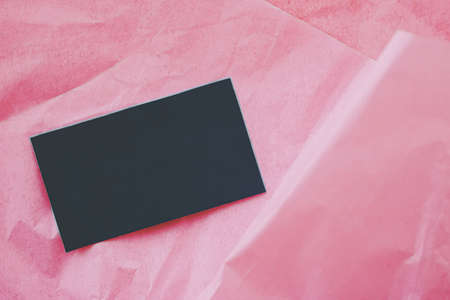 Black business card flatlay on pink tissue paper background, luxury branding flat lay and brand identity design for mockupの写真素材
