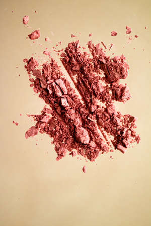 Crushed cosmetics, mineral organic eyeshadow, blush and cosmetic powder isolated on golden...