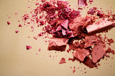 Crushed cosmetics, mineral organic eyeshadow, blush and cosmetic powder isolated on golden background, makeup and beauty banner, flatlay designの写真素材