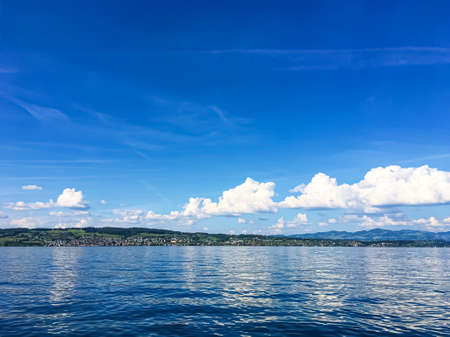 Idyllic Swiss landscape, view of lake Zurich in Richterswil, Switzerland, mountains, blue water of Zurichsee, sky as summer nature and travel destination, ideal as scenic art printの写真素材