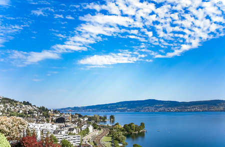 Lake Zurich in Wollerau, canton of Schwyz in Switzerland, Zurichsee, Swiss mountains landscape, blue water and sky in summer, idyllic nature and perfect travel destination, ideal as scenic art printの写真素材