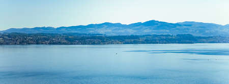 Lake Zurich in Wollerau, canton of Schwyz in Switzerland, Zurichsee, Swiss mountains landscape, blue water and sky in summer, idyllic nature and perfect travel destination, ideal as scenic art printの写真素材