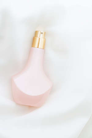 Vintage pink and gold perfume bottle and white silk, beauty and cosmeticの写真素材