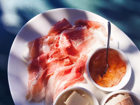 Breakfast outdoors in summer, ham, jam, butter and hamの写真素材