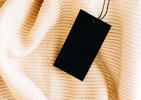 Beautiful warm fabric and black price tag as luxury shopping background, sustainable fashion and brand label conceptの写真素材