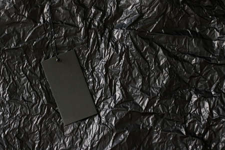 Black tag on dark background with copyspace, sustainable fashion and brand label conceptの写真素材