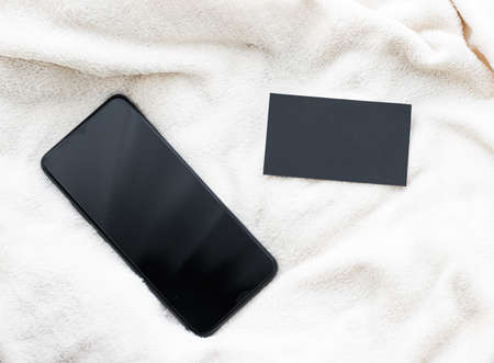 Mobile phone and black business card, smartphone flatlay mockup as app template and brand marketing designの写真素材