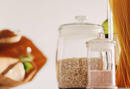 Food products in glass jars in the kitchen, pasta, cereal, salt, wine, groceries