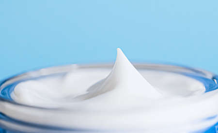 Anti-aging skincare and cosmetics, beauty face cream in jar on blue backgroundの写真素材