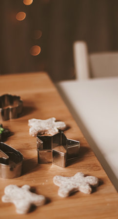 Christmas baking and cooking recipe concept. Food ingredients and preparation process of traditional homemade gingerbread men biscuits in the kitchen at home during winter holidaysの写真素材
