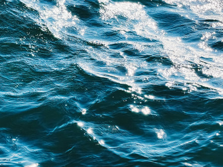 Sea, texture and coastal nature concept. Blue ocean water as surface background, flowing waves and summer holiday travelの写真素材