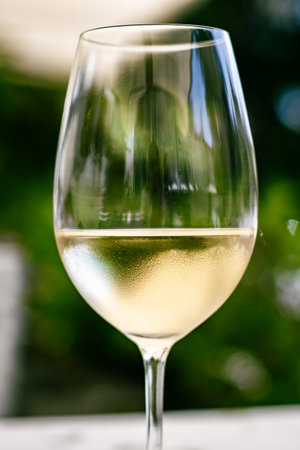 White wine in luxury restaurant on summer garden terrace, wine tasting experience at winery in the vineyard, gourmet tour and holiday travelの写真素材
