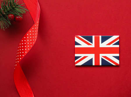 British Christmas tradition and holiday design concept. Union Jack flag of Great Britain and xmas ornaments and decoration on red background as flatlay top viewの写真素材