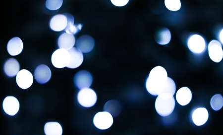Christmas time and holiday mood concept. Blurred blue xmas tree lights as bokeh backgroundの写真素材