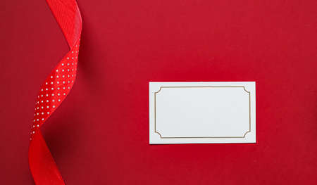 Holiday brand identity design and Christmas flatlay concept. White blank business card and xmas ornament and decoration on red paper background as flat lay mockupの写真素材