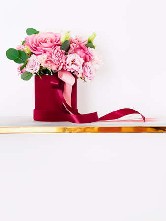Beautiful bouquet of blooming flowers in red flower box on white background, holiday gift, luxury...