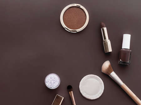 Beauty, make-up and cosmetics flatlay design with copyspace, cosmetic products and makeup tools on brown background, girly and feminine style conceptの写真素材