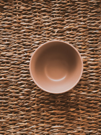 Small empty ceramic measure bowl on rustic wicker background, food preparation flatlay and cooking design conceptの写真素材