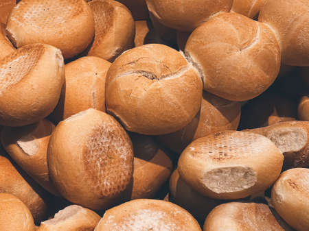 Fresh loaves of bread and buns in rustic bakery, baked goods on rustic background and countryside...