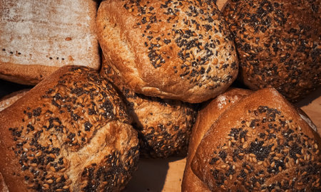 Fresh loaves of bread and buns in rustic bakery, baked goods on rustic background and countryside...