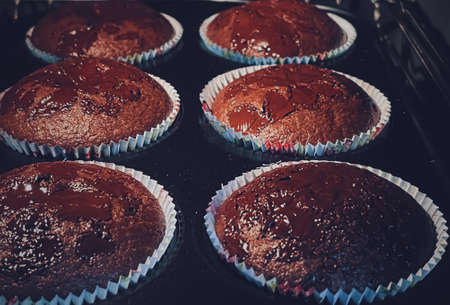 Chocolate muffins baking in the oven, homemade cakes recipe, food and cooking conceptの写真素材